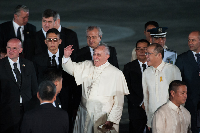 Pope Francis waves to the crowd with Philippine President Benigno Aquino upon his arrival in the Philippines on Jan. 15 in Manila. The pontiff's trip, the first by a pope to the Philippines since 1995, runs through Jan. 19.