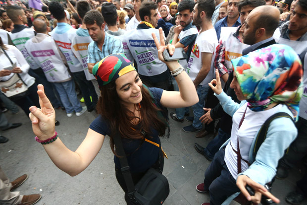 A supporter of pro-Kurdish People's Democracy Party (HDP) makes a victory sign June 9 as she celebrates election results in Ankara, Turkey.  