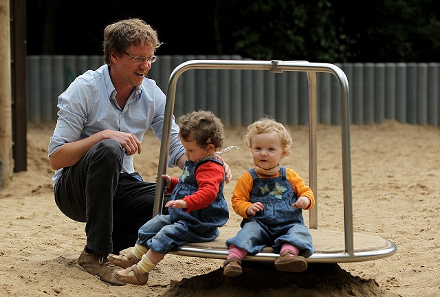 This 2010 photogrpah shows Oliver H., 42, a married federal employee on six-month paternity leave, playing with his twin 14-month-old daughters Lotte (L) and Alma at a playground  in Berlin, Germany. 