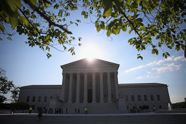 The early morning sun rises behind the U.S. Supreme Court building May 15 in Washington, DC. Today the high court sent the Affordable Care Act's contraceptive mandate case back down to the lower courts for opposing parties to work out a compromise.