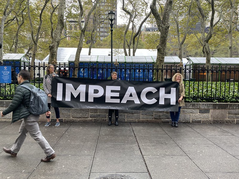 Women hold an "Impeach" sign in New York City on October 30, 2019. 