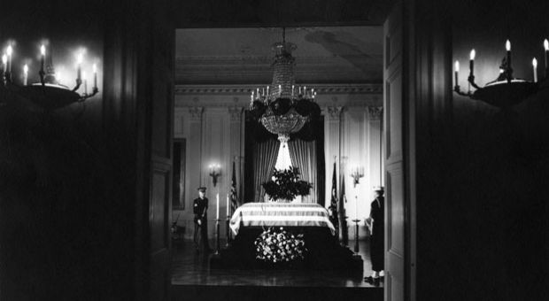 President John F. Kennedy's flag-draped casket lies in state in the East Room of the White House, Washington, D.C. Two members of the honor guard attend the casket.
